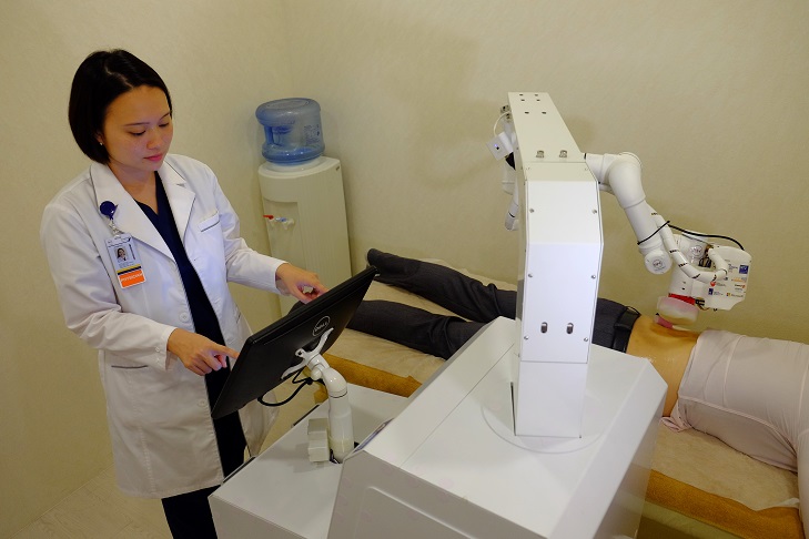 NR Banner - Calista Lim operating the Emma robot on a patient - Copy.JPG